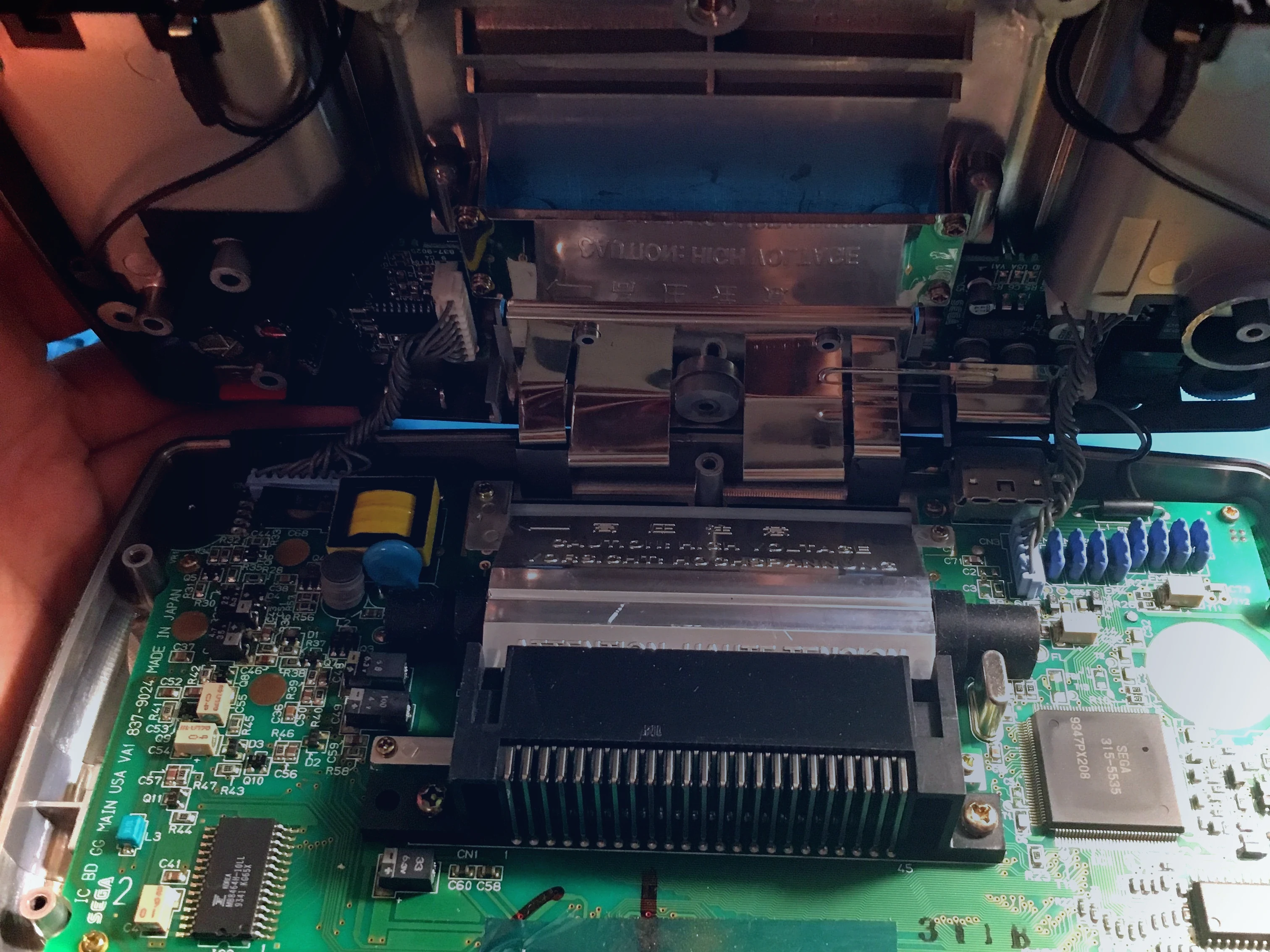 Sega Game Gear abierta con carcasa trasera retirada para iniciar la reparación